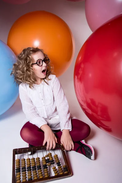 Surprised girl with open mouth in glasses with wooden abacus on — Stock Fotó