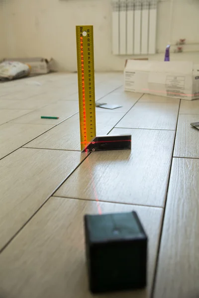 Laser Level with a square on the floor tiles. — Stock Photo, Image