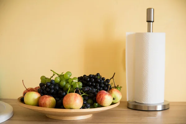 Druiven en appels in een kopje, een papieren handdoek. — Stockfoto