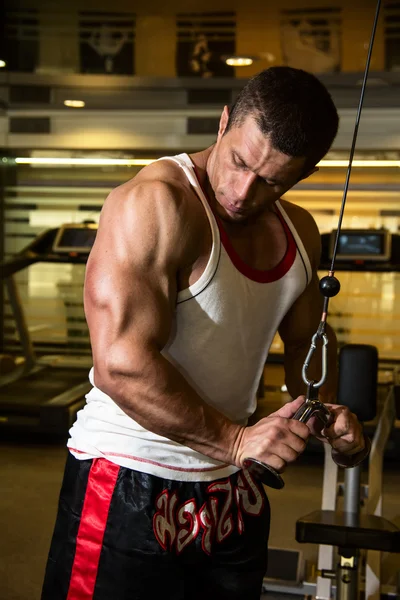 Культурист тренирует мышцы в спортзале . — стоковое фото