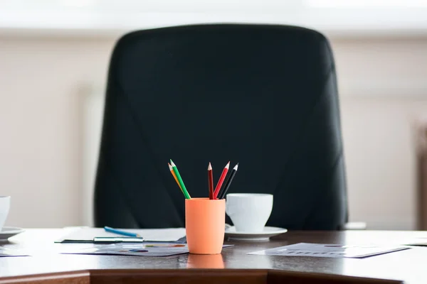 Lápices de colores en un frasco en el fondo del cha del director — Foto de Stock