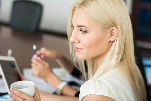 Ung framgångsrik affärskvinna på kontoret med en kopp kaff — Stockfoto