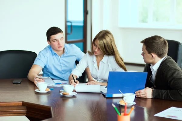 Junge Geschäftsfrau mit Geschäftspartnern, Männer in einem Geschäft — Stockfoto