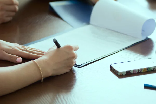 Close-up of a woman's hand signed paper document at office — Stock Photo, Image