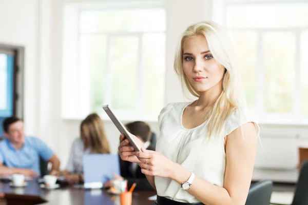 Portrait of a young business woman with a tablet computer at the — Stock Photo, Image