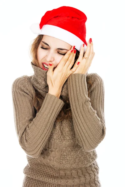Portrait of a young girl in a Santa hat hand on his cheek from a — Stock Photo, Image
