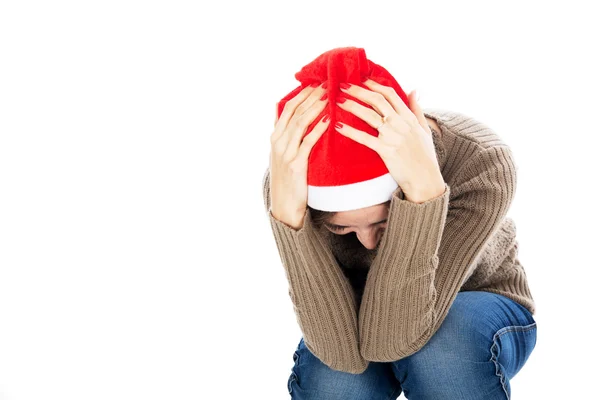 Frustrated woman in santa hat sitting with his head in his hands — Stock Photo, Image