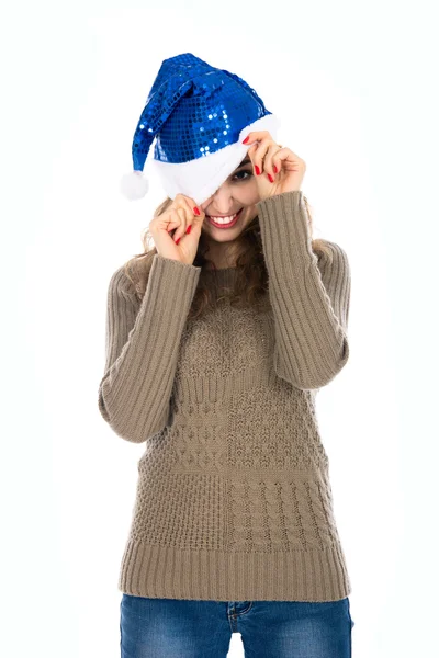 Menina sorridente com um olho espreitando fora de chapéus de Papai Noel — Fotografia de Stock