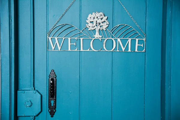 La inscripción en la puerta azul da la bienvenida — Foto de Stock