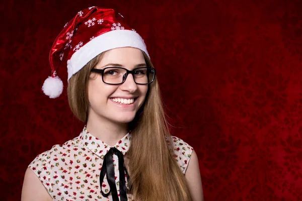 Menina sorridente bonita com óculos em chapéus de Santa olhando para o — Fotografia de Stock