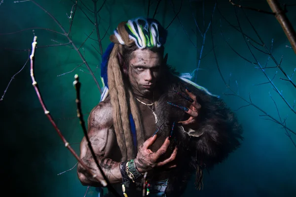 Hombre lobo musculoso con rastas con uñas largas entre el salvado — Foto de Stock