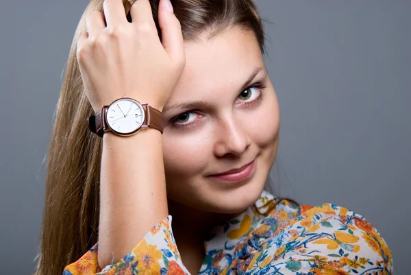 Close-up portrait of young beautiful girl with a wristwatch — Stockfoto