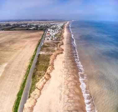 Yorkshire 'ın doğu kıyısındaki kıyı erozyonunun hava görüntüsü tehdit altındaki tatil beldesini gösteriyor.