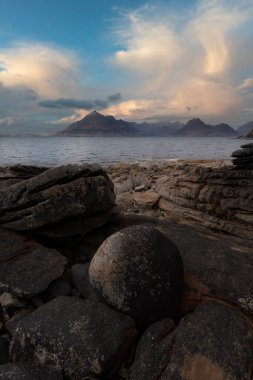 Elgol Adası 'nda gün batımında gökyüzü olan kayalık kıyı ve siyah mutfaklar.