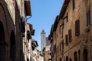 San Gimignano Toskana İtalya 'nın ana caddesi ve Torre Rignosa' nın ortasında güneşli bir günde hiç kimse