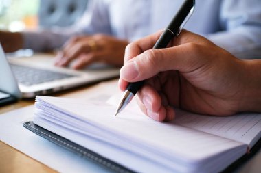 Erkek öğrenci, üniversite kampüsündeki derslere hazırlanırken taşınabilir tabletten bilgi yazar