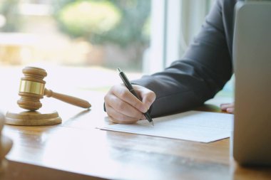 Hukuk danışmanı müvekkiline tokmak ve hukuk hukuku ile imzalanmış bir sözleşme sunar. Adalet ve avukat kavramı