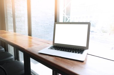 Ofis penceresi teknolojisi kavramının önündeki tahta masada boş ekranlı dizüstü bilgisayar.