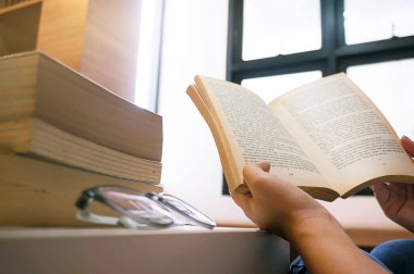 Kadınlar kitap okuyor ve oturma odasında dinleniyorlar. Seçici bir odak noktası..