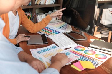 Grafik tasarımcısı dijital tablet üzerinde çalışıyor. Grafik tablet ve renk örneklerine resim çizen sanatçı