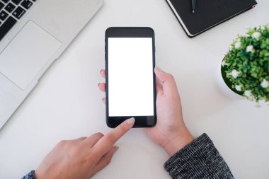 Ofiste akıllı telefon kullanan bir kız. el ele tutuşan akıllı telefon beyaz ekran.