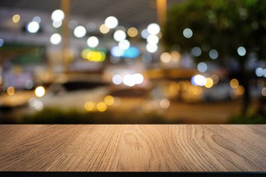 Restoranın soyut bulanık arka planının önündeki boş, siyah ahşap masa. Ürünlerinizi görüntülemek ya da montajlamak için kullanılabilir.