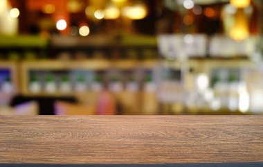 Restoranın soyut bulanık arka planının önündeki boş, siyah ahşap masa. Ürünlerinizi görüntülemek ya da montajlamak için kullanılabilir. 