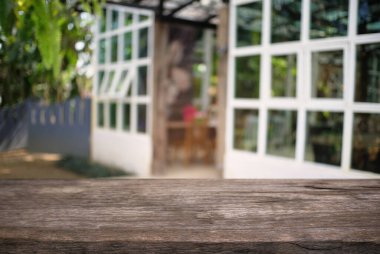 Açık hava bahçe ışıklarının soyut bulanık arka planının önündeki ahşap masa resmi. Ürünlerinizi görüntülemek veya montajlamak için kullanılabilir. Ürünün görüntülenmesi için modelleyin