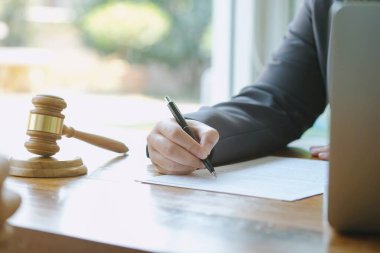 Hukuk danışmanı müvekkiline tokmak ve hukuk hukuku ile imzalanmış bir sözleşme sunar. Adalet ve avukat kavramı