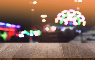 Restoranın soyut bulanık arka planının önündeki boş, siyah ahşap masa. Ürünlerinizi görüntülemek ya da montajlamak için kullanılabilir. 