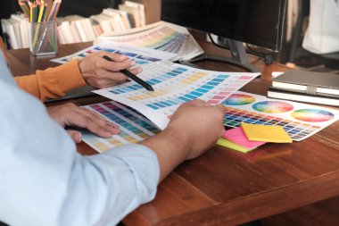 Grafik tasarımcısı dijital tablet üzerinde çalışıyor. Grafik tablet ve renk örneklerine resim çizen sanatçı