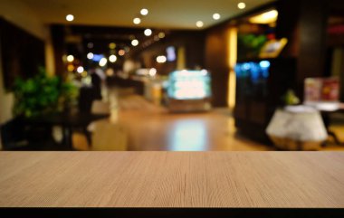 Restoranın soyut bulanık arka planının önündeki boş, siyah ahşap masa. Ürünlerinizi görüntülemek ya da montajlamak için kullanılabilir. 