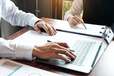 Yatırım çizelgelerini analiz eden ve belgelerin üzerindeki hesap makinesi tuşlarına basan bir işadamı. Muhasebe Kavramı