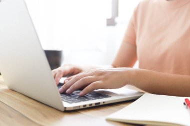 Koruyucu maske takan bir kadın. COVID-19 Pandemic Coronavirus, SARS-CoV-2 virüsünün yayılması için yüz maskesi takıyor. Evden çalışıyor ve dezenfektanla el temizliyor..