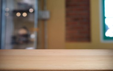 Restoranın soyut bulanık arka planının önündeki boş, siyah ahşap masa. Ürünlerinizi görüntülemek ya da montajlamak için kullanılabilir. 