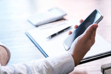 İş adamı elini tutar, akıllı telefonu tutar. teknoloji kavramı.