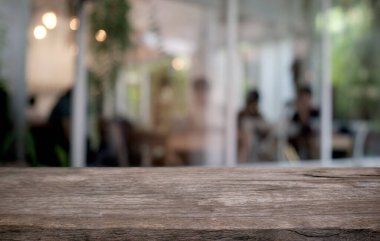 Restoranın soyut bulanık arka planının önündeki boş, siyah ahşap masa. Ürünlerinizi görüntülemek ya da montajlamak için kullanılabilir.