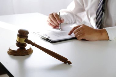 Hukuk danışmanı müvekkiline tokmak ve hukuk hukuku ile imzalanmış bir sözleşme sunar. Adalet ve avukat kavramı