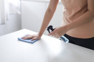 Coronavirus veya Covid-19 'u önlemek için alkol anti bakteriyel dezenfektan spreyi sıkan kadın.