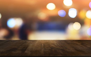 Restoranın soyut bulanık arka planının önündeki boş, siyah ahşap masa. Ürünlerinizi görüntülemek ya da montajlamak için kullanılabilir. 