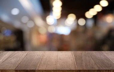 Restoranın soyut bulanık arka planının önündeki boş, siyah ahşap masa. Ürünlerinizi görüntülemek ya da montajlamak için kullanılabilir. 