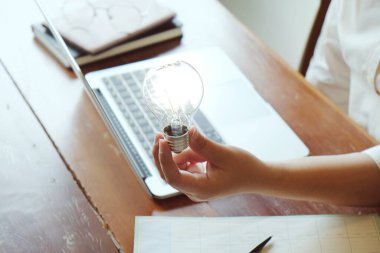 İş adamının ampul kavramını elinde tutması fikri ampullerle yaratıcılık
