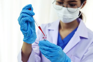 Coronavirus covid-19 'u tutan bilim adamı enfekte olmuş kan örneği tüpü. Kan örneği toplama tüpleri ve şırınga Coronavirus Covid-19 aşı araştırmalarıyla laboratuvardaki kanın DNA testi.