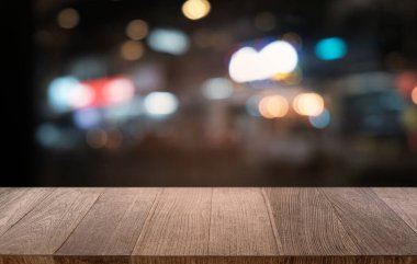 Restoranın soyut bulanık arka planının önündeki boş, siyah ahşap masa. Ürünlerinizi görüntülemek ya da montajlamak için kullanılabilir. 