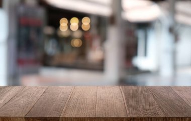 Restoranın soyut bulanık arka planının önündeki boş, siyah ahşap masa. Ürünlerinizi görüntülemek ya da montajlamak için kullanılabilir.