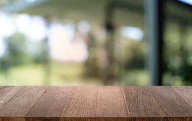Restoranın soyut bulanık arka planının önündeki boş, siyah ahşap masa. Ürünlerinizi görüntülemek ya da montajlamak için kullanılabilir. 