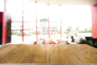 Restoranın soyut bulanık arka planının önündeki boş ahşap masa. Ürünlerinizi görüntülemek veya montajlamak için kullanılabilir. Tezgahın görüntülenmesi için ayarlayın