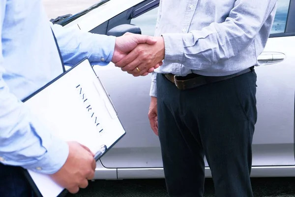 Loss Adjuster Insurance Agent handshake with Inspecting Damaged Car