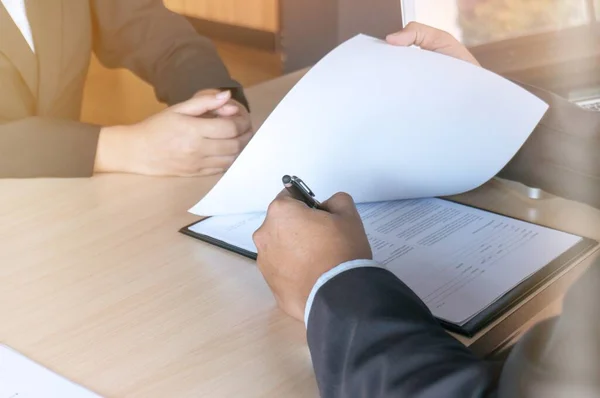 View of a Examiner reading a resume during a job interview.