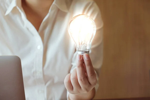 Idea of business person holding light bulb concept creativity with bulbs